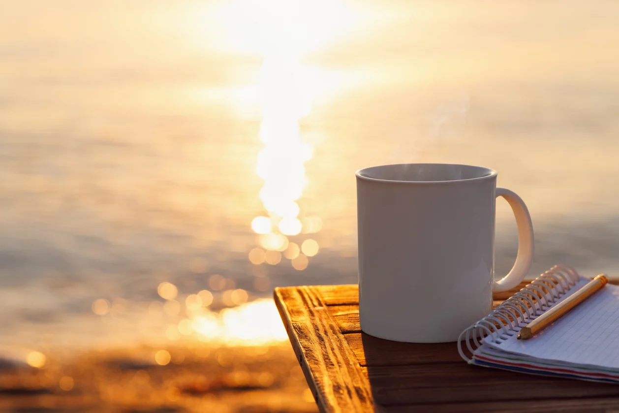 Mug of coffee and journal on table